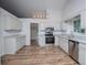 Spacious kitchen features white cabinets, stainless steel appliances, and modern lighting at 9691 Squirrel Wood Run, Douglasville, GA 30135