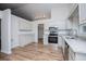 Beautiful kitchen with white cabinetry, stainless appliances, granite counters, and wood floors at 9691 Squirrel Wood Run, Douglasville, GA 30135
