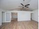 Open living room with hardwood floors, vaulted ceiling, fan, and open doorways to nearby rooms at 9691 Squirrel Wood Run, Douglasville, GA 30135