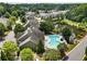 Aerial view of the community pool area next to a lake, surrounded by lush trees and well-kept landscaping at 1896 Grove Field Ln # 29, Marietta, GA 30064