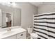 Neutral bathroom featuring a toilet, vanity with a white sink, mirror and shower with striped curtain at 1896 Grove Field Ln # 29, Marietta, GA 30064