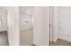 Hallway view into bathroom and bedroom with neutral carpet and white walls at 281 Sandy Oak Dr, Loganville, GA 30052
