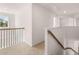 Bright hallway with neutral carpet and wooden handrail on the staircase at 281 Sandy Oak Dr, Loganville, GA 30052