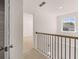 Upstairs hallway featuring modern metal railing, neutral carpet and window view at 281 Sandy Oak Dr, Loganville, GA 30052