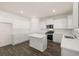 White kitchen with a center island, stainless steel appliances, and dark hardwood floors at 281 Sandy Oak Dr, Loganville, GA 30052