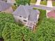 The rear exterior of the house features a pergola-covered deck and is surrounded by mature trees and greenery at 310 Arbor Creek Trl, Roswell, GA 30076
