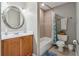 Cozy bathroom with wooden vanity, neutral tile, and shower-tub combo at 310 Arbor Creek Trl, Roswell, GA 30076