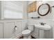 Charming half-bathroom with white wainscoting, a pedestal sink, and wood-look flooring at 310 Arbor Creek Trl, Roswell, GA 30076