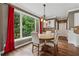 Charming dining area with a round table, large window views, and adjacent white kitchen cabinets at 310 Arbor Creek Trl, Roswell, GA 30076