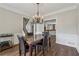 Dining area with a large table, chandelier, and seamless flow to the staircase and kitchen at 310 Arbor Creek Trl, Roswell, GA 30076