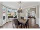 Elegant dining room with bay windows, a modern chandelier, and views of the front yard at 310 Arbor Creek Trl, Roswell, GA 30076