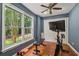 This exercise room has a large window and includes a stationary bike, bench, and free weights at 310 Arbor Creek Trl, Roswell, GA 30076