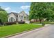 This charming two-story home has a manicured lawn, lush shrubbery, and mature trees at 310 Arbor Creek Trl, Roswell, GA 30076