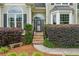 Welcoming front entrance with stone steps, lush greenery, and charming architectural details at 310 Arbor Creek Trl, Roswell, GA 30076