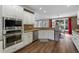 Bright kitchen featuring white cabinetry, stainless steel appliances, granite countertops, and wood flooring at 310 Arbor Creek Trl, Roswell, GA 30076