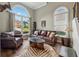 Inviting living room featuring a leather sofa, large windows, and a unique animal print rug at 310 Arbor Creek Trl, Roswell, GA 30076