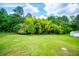 Backyard with green grass, mature trees, and a small storage shed at 6213 Cherry Ln, Douglasville, GA 30134