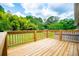 Wooden deck with wooden railings overlooks backyard with green grass and mature trees at 6213 Cherry Ln, Douglasville, GA 30134
