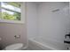 Bathroom with white tiled walls, a window, and a built-in niche shelf at 6213 Cherry Ln, Douglasville, GA 30134