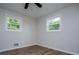 Bedroom with hardwood floors, light-colored walls, and two windows providing natural light at 6213 Cherry Ln, Douglasville, GA 30134
