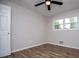 Bedroom with wood flooring, ceiling fan, fresh paint, and bright light from window at 6213 Cherry Ln, Douglasville, GA 30134
