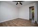 Bedroom with wood flooring, ceiling fan, fresh paint, and a doorway to the bathroom at 6213 Cherry Ln, Douglasville, GA 30134