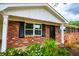 Brick home with traditional black shutters and covered porch surrounded by colorful landscaping at 6213 Cherry Ln, Douglasville, GA 30134