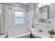 Cozy bathroom featuring tile shower over tub, glass shelving, and sink with dark vanity at 628 Home Se Ave, Atlanta, GA 30312