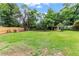 Expansive backyard with lush lawn, mature trees, and a wooden fence, perfect for outdoor activities and relaxation at 821 Springvalley Dr, Forest Park, GA 30297