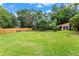 Large backyard featuring a well-maintained lawn, shade trees, and a storage shed, offering ample space and utility at 821 Springvalley Dr, Forest Park, GA 30297