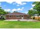 Rear exterior view of brick home featuring a patio area and a spacious backyard with well-manicured grass at 821 Springvalley Dr, Forest Park, GA 30297