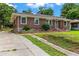Charming brick home with a well-maintained front yard, landscaped garden beds, and a paved driveway at 821 Springvalley Dr, Forest Park, GA 30297