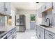 Updated kitchen with stainless steel refrigerator, gray cabinets and quartz countertops at 821 Springvalley Dr, Forest Park, GA 30297