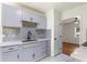 Stylish kitchen with gray cabinets, modern backsplash, and a view into another room at 821 Springvalley Dr, Forest Park, GA 30297