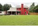 Expansive backyard of a red home featuring a large grassy area, a patio, and partial fence at 1809 Brandi Ln, Loganville, GA 30052