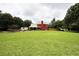 Spacious backyard featuring a well-maintained lawn, red house, trampoline, and plenty of room for outdoor activities at 1809 Brandi Ln, Loganville, GA 30052