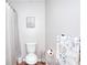 Clean bathroom featuring a shower with a white curtain, toilet, and towel rack with playful kitten towels at 1809 Brandi Ln, Loganville, GA 30052