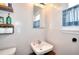Simple bathroom with a classic white sink, wood shelves, and bright natural light at 1809 Brandi Ln, Loganville, GA 30052