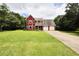 Charming red two-story home with a well-maintained lawn and a two-car attached garage at 1809 Brandi Ln, Loganville, GA 30052
