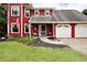 Charming red two-story home with a well-maintained lawn and a two-car attached garage at 1809 Brandi Ln, Loganville, GA 30052