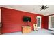 Enclosed patio with red paneled walls, ceiling fan, and television; great for entertaining at 1809 Brandi Ln, Loganville, GA 30052