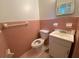 Powder room featuring pink tiling, a toilet, and a sink with vanity with hexagon tile floor at 3098 Henderson Mill Rd, Atlanta, GA 30341