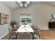 Staged dining room with neutral colors, modern lighting, and large window with lush outdoor views at 4398 Stonebridge Ct, Duluth, GA 30096