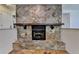 Close-up view of a stone fireplace with a dark wooden mantel in a cozy living room at 4398 Stonebridge Ct, Duluth, GA 30096