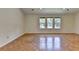 Spacious living room with hardwood floors, three large windows, and recessed lighting at 4398 Stonebridge Ct, Duluth, GA 30096