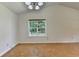 Spacious living room with hardwood floors, vaulted ceiling, and a large window with outside views at 4398 Stonebridge Ct, Duluth, GA 30096