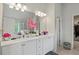 Bright bathroom with double vanity, white cabinets, granite countertop, and decorative pink floral arrangement at 7207 Gladstone Cir, Stonecrest, GA 30038