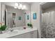 Bright bathroom featuring a wide mirror over the vanity, white cabinets, and a shower/tub combo with floral curtain at 7207 Gladstone Cir, Stonecrest, GA 30038