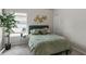 Inviting bedroom with green bedspread and pillows, complemented by a decorative wall art and natural lighting at 7207 Gladstone Cir, Stonecrest, GA 30038