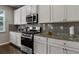 Well-lit kitchen featuring stainless steel appliances, gray subway tile backsplash, and granite countertops at 7207 Gladstone Cir, Stonecrest, GA 30038